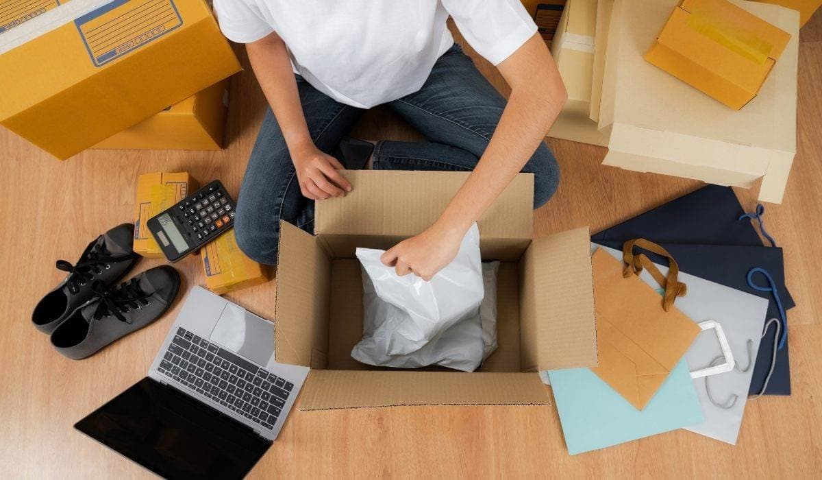 After selling online, man packs products to deliver to customer